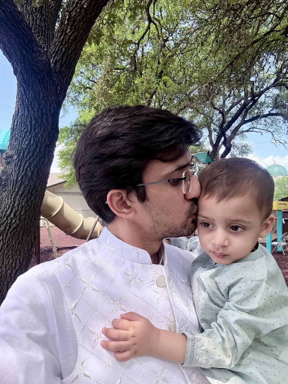 Umair kissing his son on Eid in Austin, June 2025