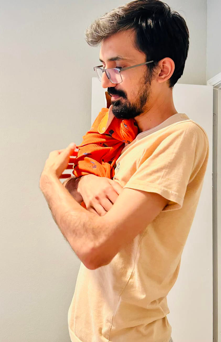 Umair holding his newborn son, 2024